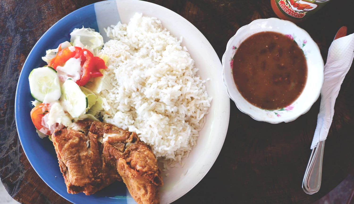 Typisches Essen in Belize: Stewed Chicken mit Reis und Bohnen Typisches Essen in Belize: Stewed Chicken mit Reis und Bohnen
